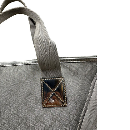 Borsa Gucci in canvas grigio laminato GG con finiture in pelle Tono su tono e parti metalliche argentate. Dotata di Doppi manici e tracolla in tessuto regolabile.