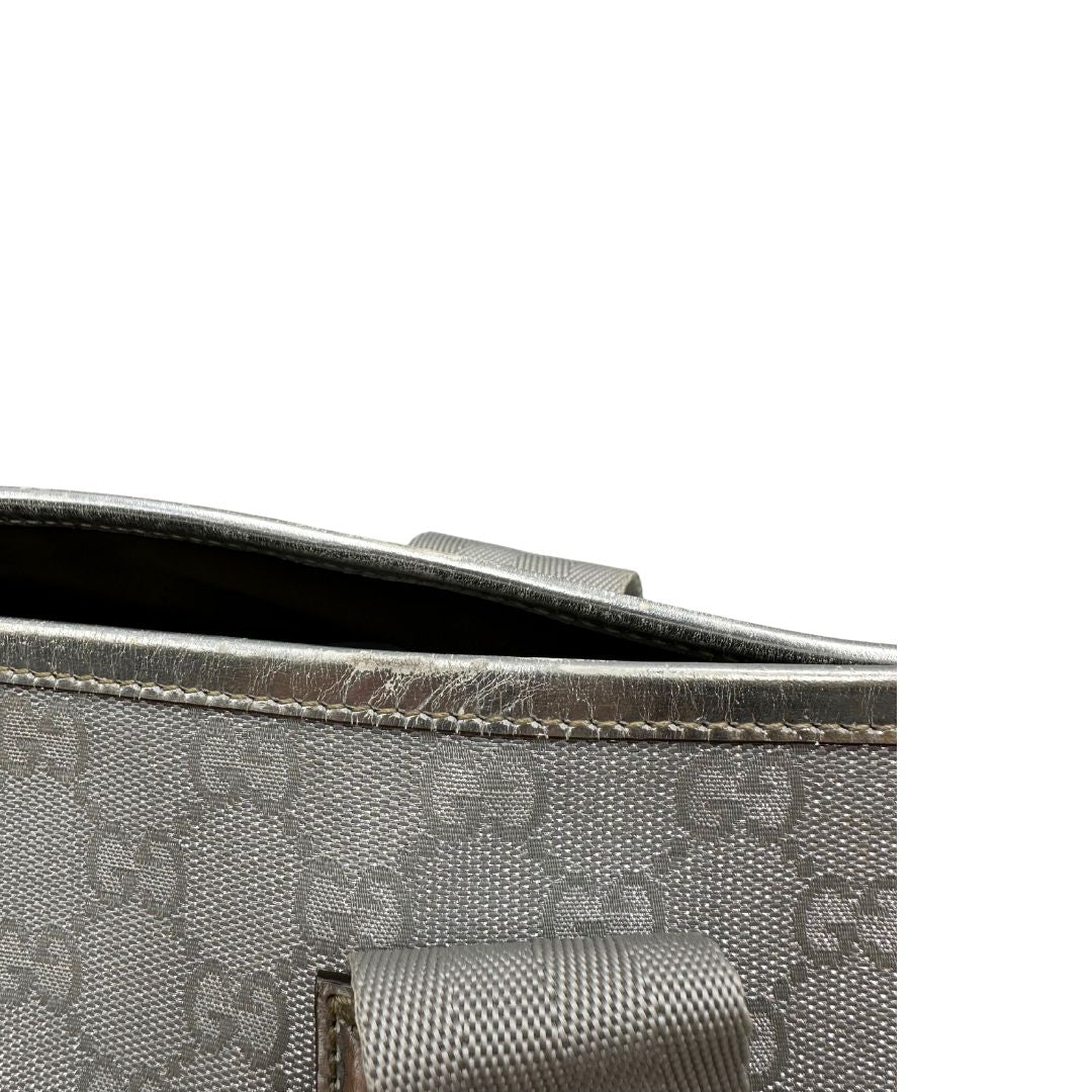 Borsa Gucci in canvas grigio laminato GG con finiture in pelle Tono su tono e parti metalliche argentate. Dotata di Doppi manici e tracolla in tessuto regolabile.