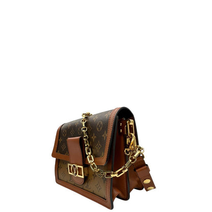 Laterali Borsa Dauphine MM Louis Vuitton in tela monogram, e monogram reverse bicolore con finiture in pelle cognac e parti metalliche dorate. Munita di una tracolla in pelle e un manico in catena, amovibili. Originale, usato, di lusso, in ottime condizioni 