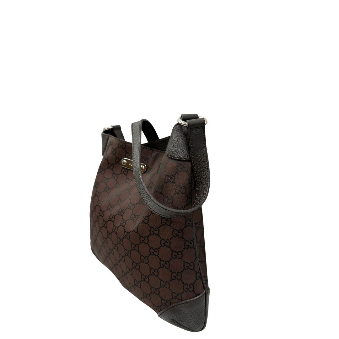 Laterale destro di una borsa Gucci in tessuto marrone GG con finiture in pelle tono su tono e parti metalliche argentate; munita di un manico singolo, indossabile a spalla.