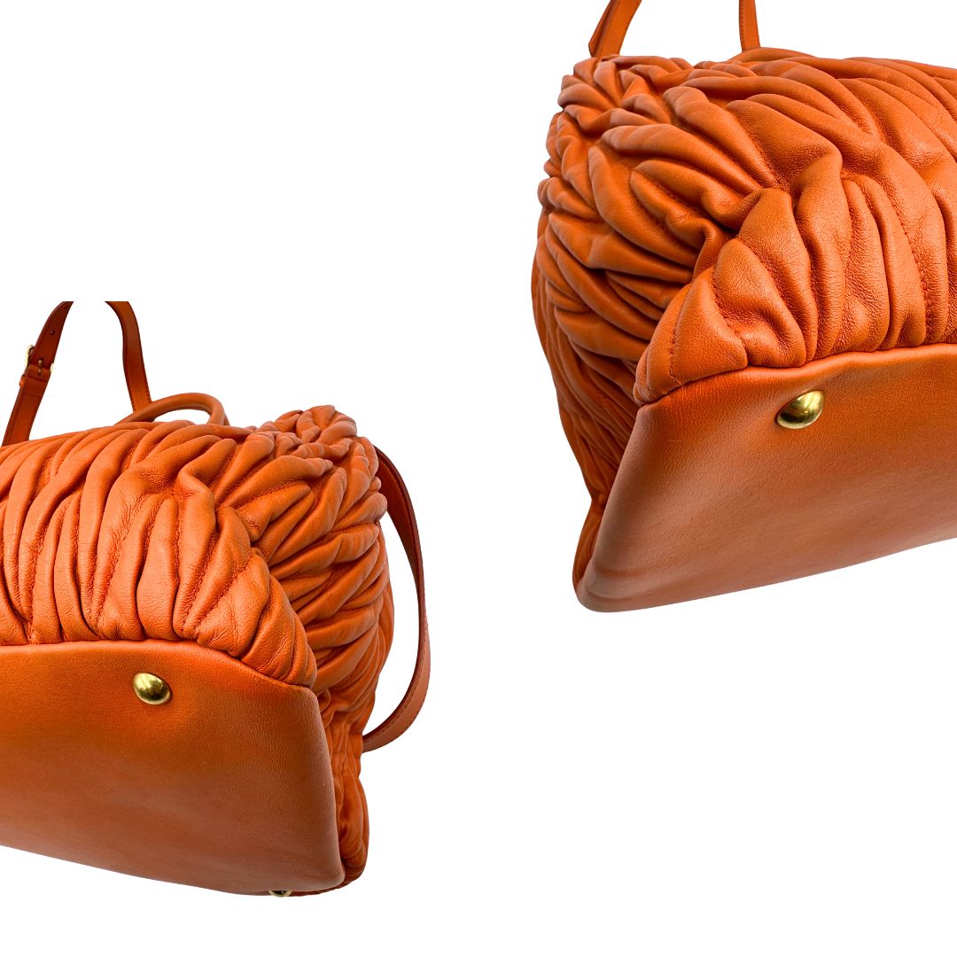 Angoli di una Borsa Miu Miu realizzata in nappa matelassé arancione con parti metalliche dorate; munita di due manici stondati e una tracolla regolabile amovibile. Originale, usata, di lusso, in ottime condizioni