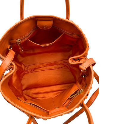 Interno di una Borsa Miu Miu realizzata in nappa matelassé arancione con parti metalliche dorate; munita di due manici stondati e una tracolla regolabile amovibile. Originale, usata, di lusso, in ottime condizioni