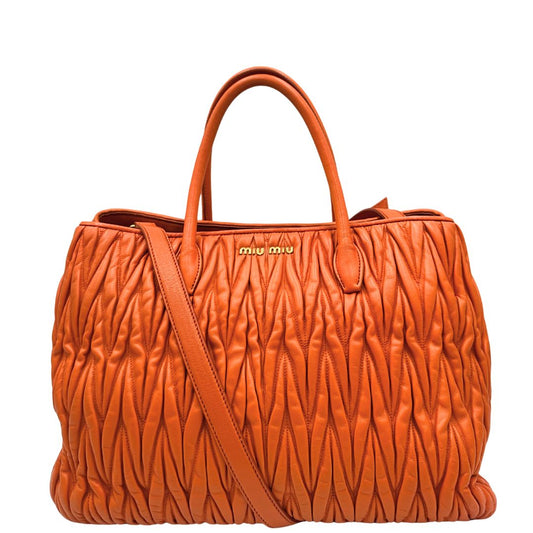 Front di una Borsa Miu Miu realizzata in nappa matelassé arancione con parti metalliche dorate; munita di due manici stondati e una tracolla regolabile amovibile. Originale, usata, di lusso, in ottime condizioni