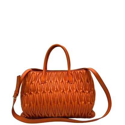 Retro di una Borsa Miu Miu realizzata in nappa matelassé arancione con parti metalliche dorate; munita di due manici stondati e una tracolla regolabile amovibile. Originale, usata, di lusso, in ottime condizioni