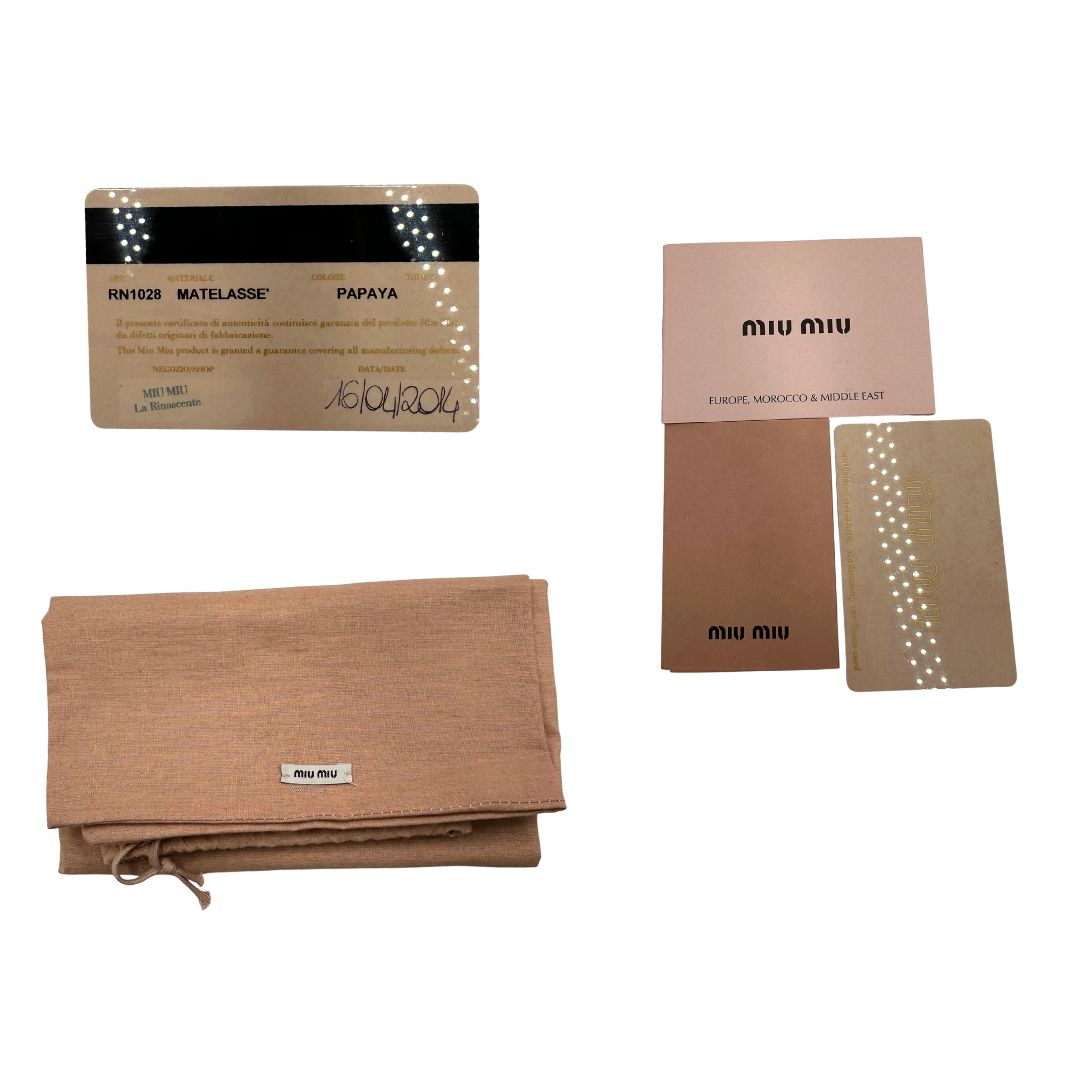 Borsa Miu Miu realizzata in nappa matelassé arancione con parti metalliche dorate; munita di due manici stondati e una tracolla regolabile amovibile. Originale, usata, di lusso, in ottime condizioni