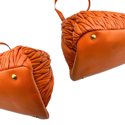 Angoli di una Borsa Miu Miu realizzata in nappa matelassé arancione con parti metalliche dorate; munita di due manici stondati e una tracolla regolabile amovibile. Originale, usata, di lusso, in ottime condizioni