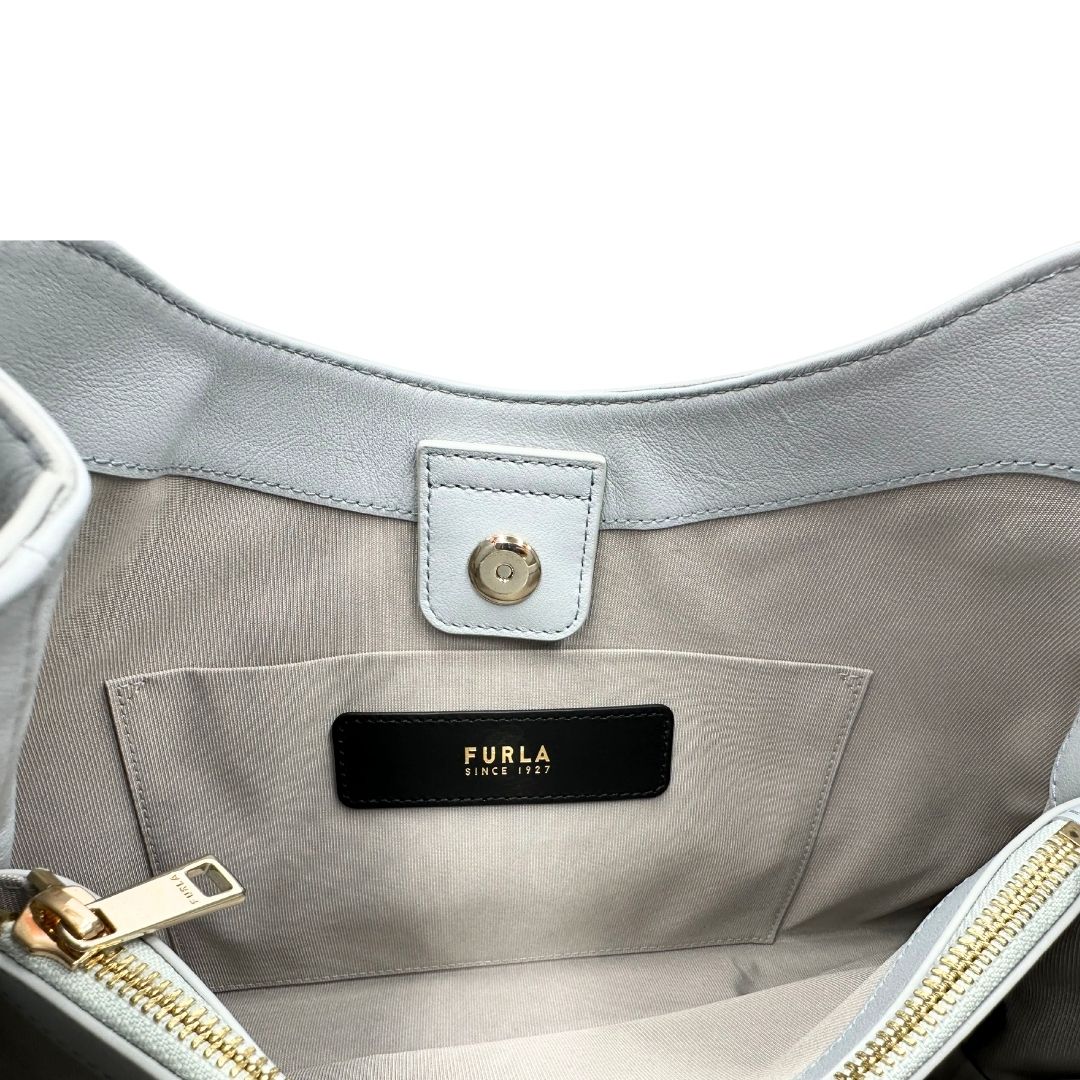 interno  Borsa Furla Nuvola in pelle azzurro polvere con parti metalliche dorate; munita di un manico regolabile e rimovibile. Originale, usata, di lusso, in eccellenti condizioni