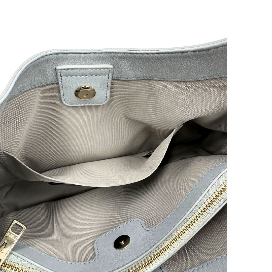 interno  Borsa Furla Nuvola in pelle azzurro polvere con parti metalliche dorate; munita di un manico regolabile e rimovibile. Originale, usata, di lusso, in eccellenti condizioni