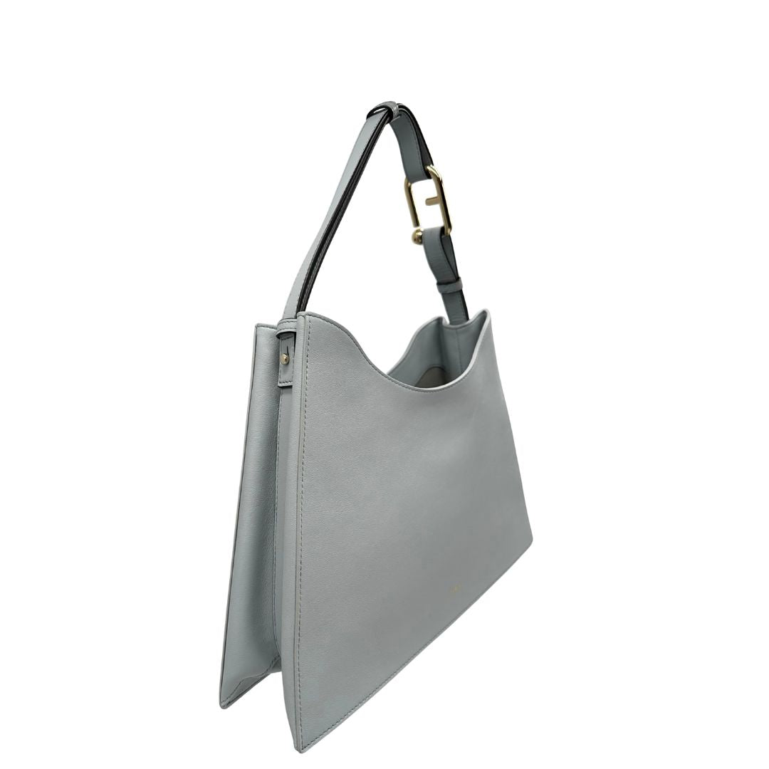 lato  Borsa Furla Nuvola in pelle azzurro polvere con parti metalliche dorate; munita di un manico regolabile e rimovibile. Originale, usata, di lusso, in eccellenti condizioni