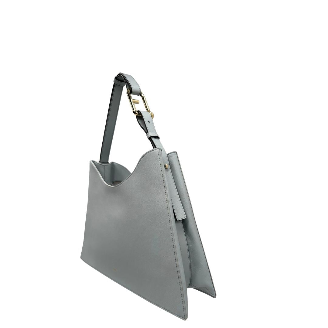 lato  Borsa Furla Nuvola in pelle azzurro polvere con parti metalliche dorate; munita di un manico regolabile e rimovibile. Originale, usata, di lusso, in eccellenti condizioni