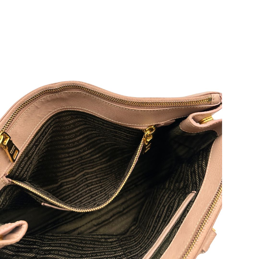 interno Borsa Prada in pelle saffiano rosa con parti metalliche dorate, munita di doppi manici stondati e una clochette portachiavi, di lusso, originale, usata.
