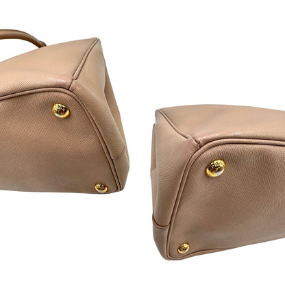 angoli Borsa Prada in pelle saffiano rosa con parti metalliche dorate, munita di doppi manici stondati e una clochette portachiavi, di lusso, originale, usata. 