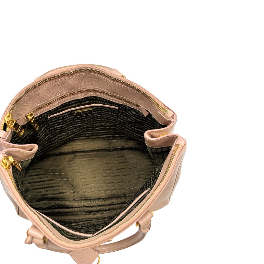 interno Borsa Prada in pelle saffiano rosa con parti metalliche dorate, munita di doppi manici stondati e una clochette portachiavi, di lusso, originale, usata.