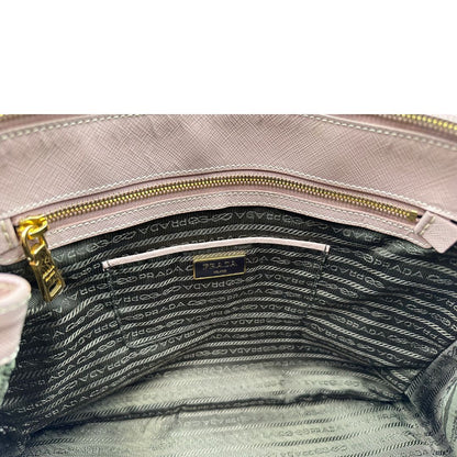interno Borsa Prada in pelle saffiano rosa con parti metalliche dorate, munita di doppi manici stondati e una clochette portachiavi, di lusso, originale, usata.