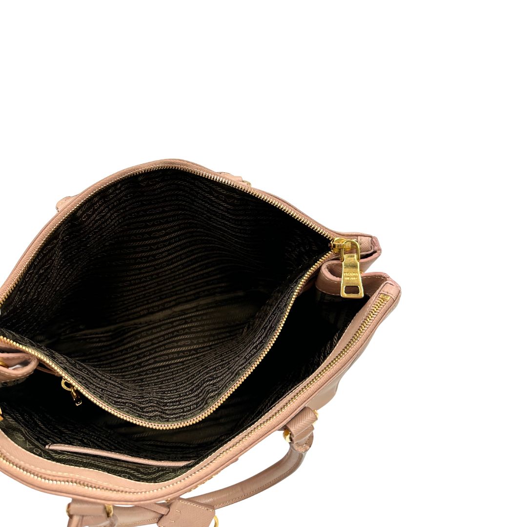 interno Borsa Prada in pelle saffiano rosa con parti metalliche dorate, munita di doppi manici stondati e una clochette portachiavi, di lusso, originale, usata.