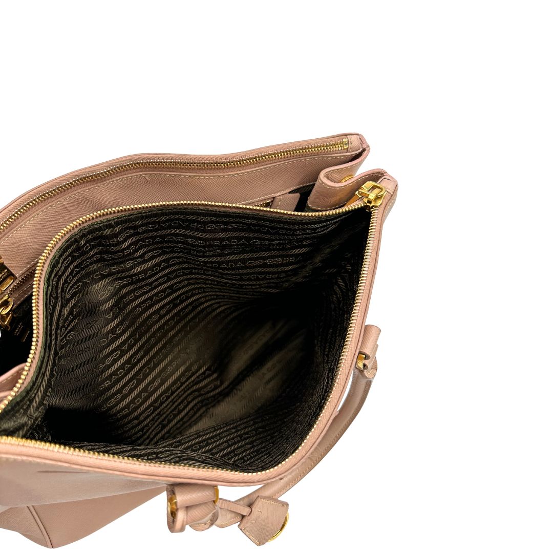 interno Borsa Prada in pelle saffiano rosa con parti metalliche dorate, munita di doppi manici stondati e una clochette portachiavi, di lusso, originale, usata.