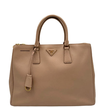 front Borsa Prada in pelle saffiano rosa con parti metalliche dorate, munita di doppi manici stondati e una clochette portachiavi, di lusso, originale, usata. 