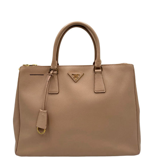 front Borsa Prada in pelle saffiano rosa con parti metalliche dorate, munita di doppi manici stondati e una clochette portachiavi, di lusso, originale, usata. 