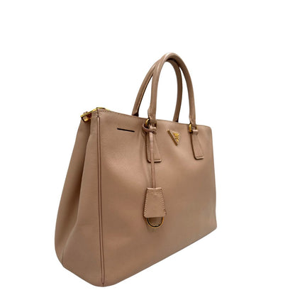 lato Borsa Prada in pelle saffiano rosa con parti metalliche dorate, munita di doppi manici stondati e una clochette portachiavi, di lusso, originale, usata. 