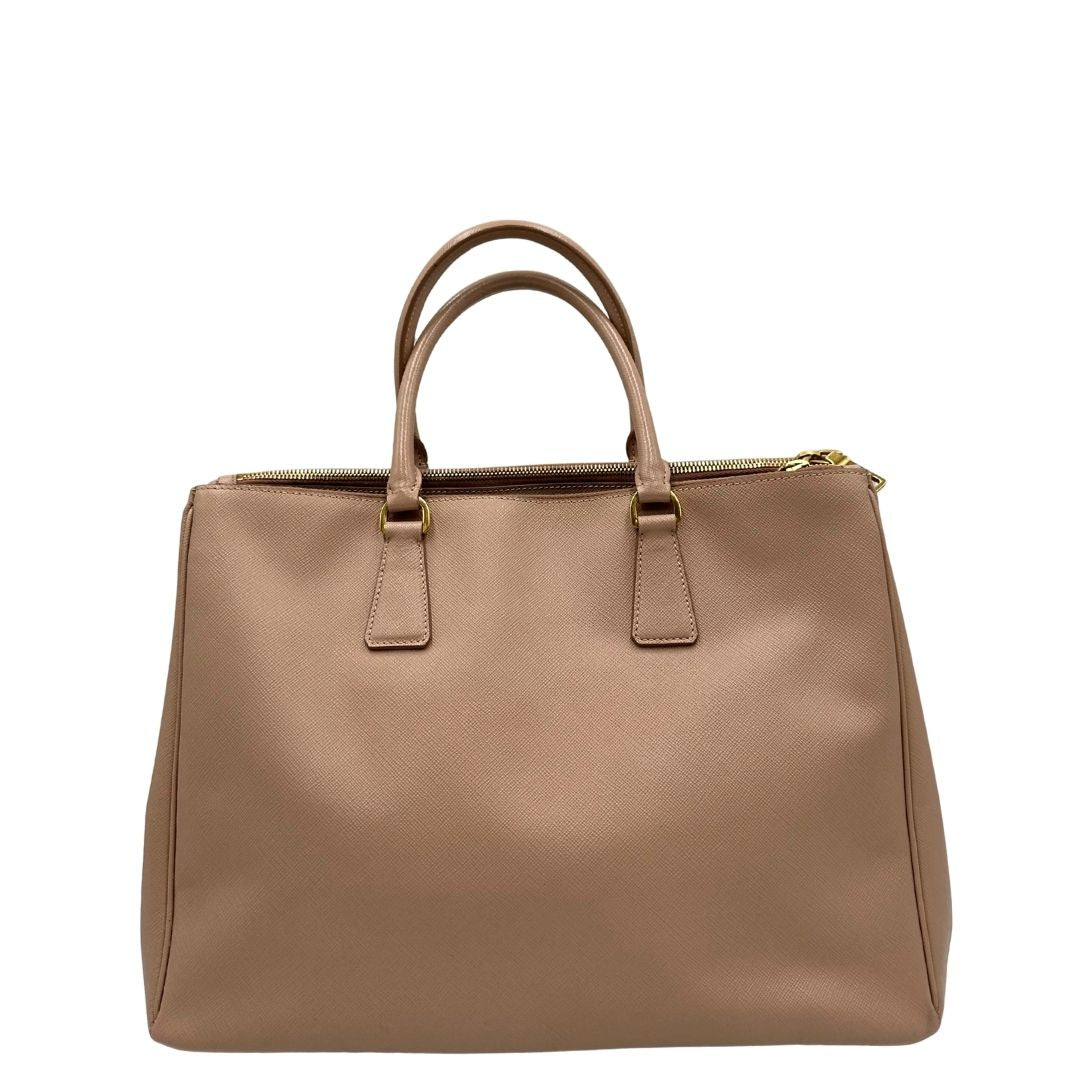 retro Borsa Prada in pelle saffiano rosa con parti metalliche dorate, munita di doppi manici stondati e una clochette portachiavi, di lusso, originale, usata. 