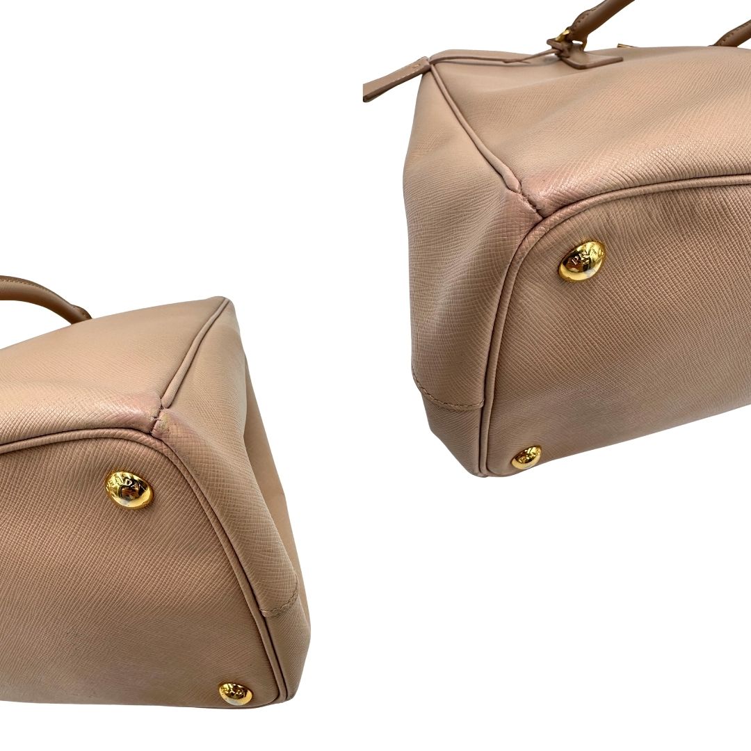 angoli Borsa Prada in pelle saffiano rosa con parti metalliche dorate, munita di doppi manici stondati e una clochette portachiavi, di lusso, originale, usata.