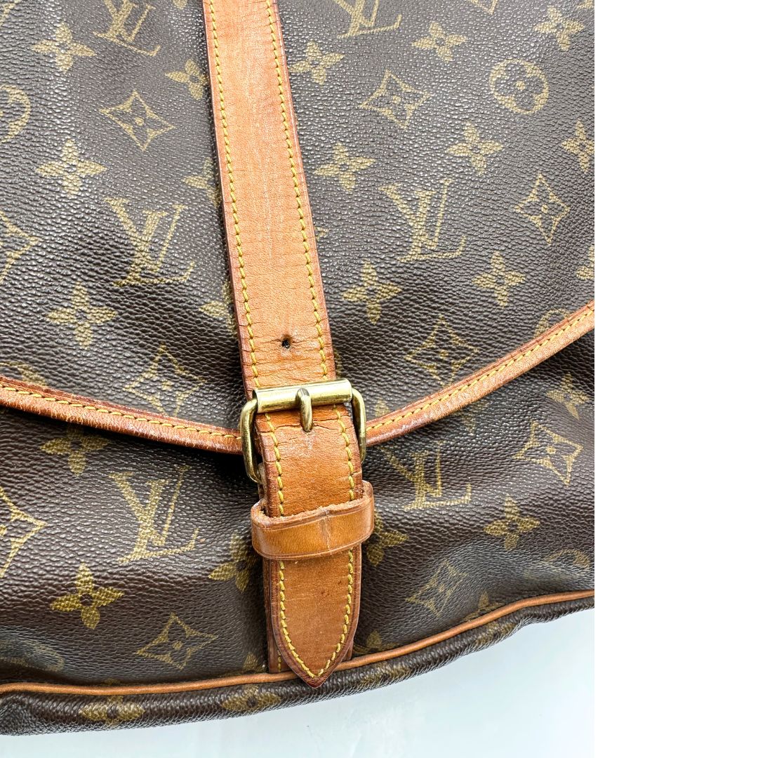 Borsa Saumur 35 Louis Vuitton in canvas marrone monogram con finiture in vacchetta naturale e parti metalliche dorate; da indossare a tracolla. Originale, usata, di lusso, in ottime condizioni
