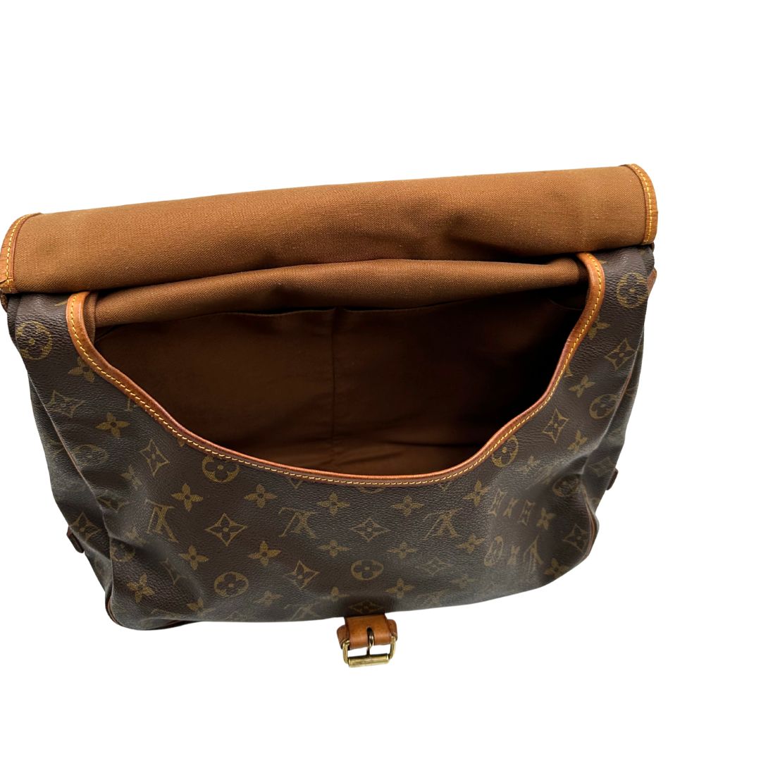 Interno di una Borsa Saumur 35 Louis Vuitton in canvas marrone monogram con finiture in vacchetta naturale e parti metalliche dorate; da indossare a tracolla. Originale, usata, di lusso, in ottime condizioni