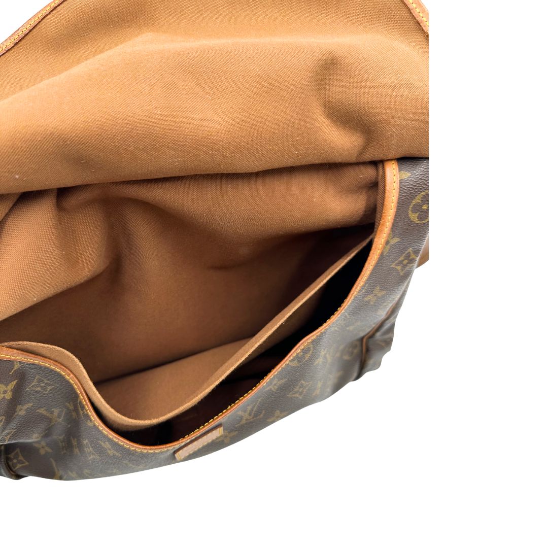 Interno di ua Borsa Saumur 35 Louis Vuitton in canvas marrone monogram con finiture in vacchetta naturale e parti metalliche dorate; da indossare a tracolla. Originale, usata, di lusso, in ottime condizioni