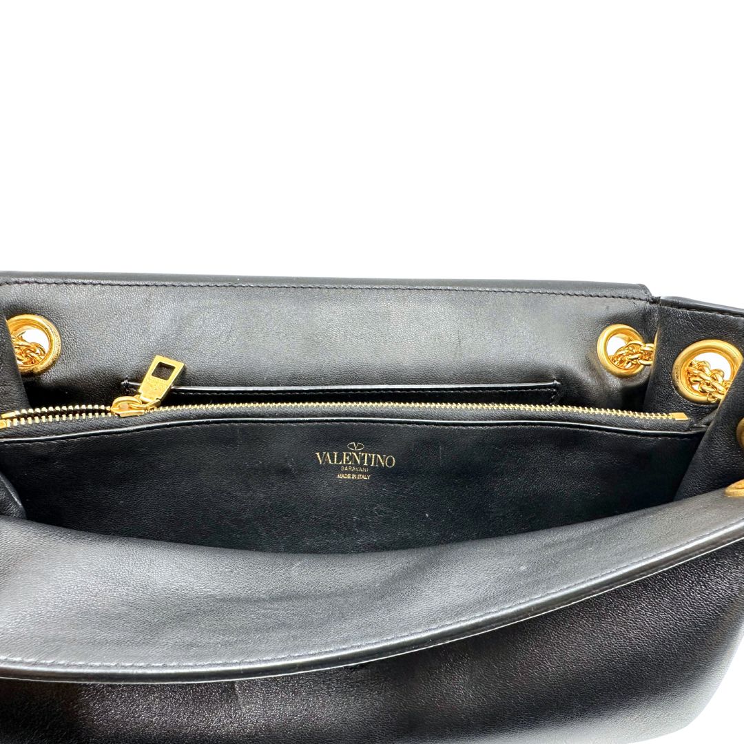 Interno di una Borsa Stud Sign Valentino Garavani in pelle nera con parti metalliche dorate e tracolla in catena scorrevole con borchie piramidali dorate sullo spallaccio. Completa di dustbag e cartellino. Originale, usata, di lusso, in ottime condizioni