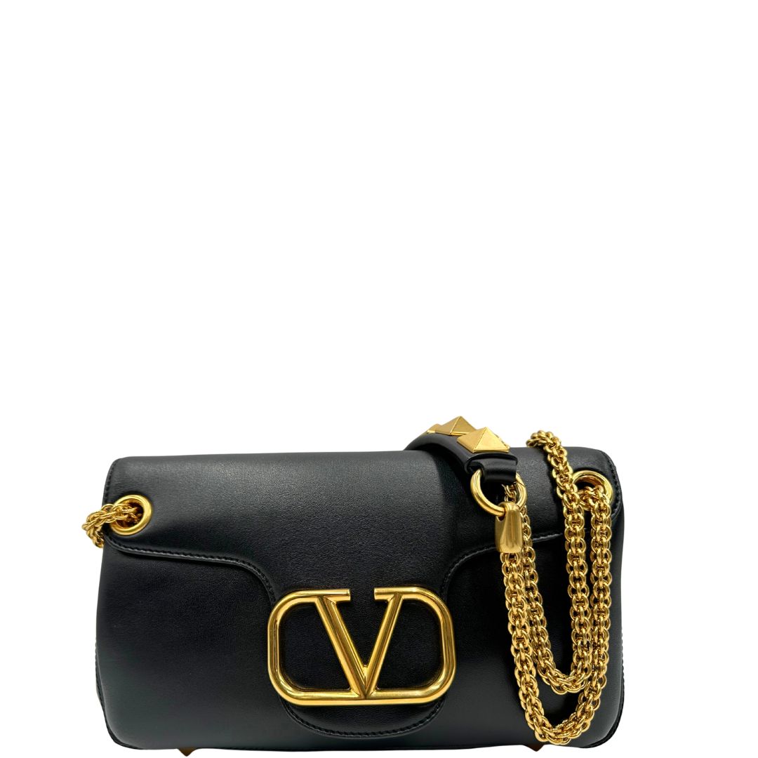 Front di una Borsa Stud Sign Valentino Garavani in pelle nera con parti metalliche dorate e tracolla in catena scorrevole con borchie piramidali dorate sullo spallaccio. Completa di dustbag e cartellino. Originale, usata, di lusso, in ottime condizioni