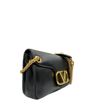 Lato destro di una Borsa Stud Sign Valentino Garavani in pelle nera con parti metalliche dorate e tracolla in catena scorrevole con borchie piramidali dorate sullo spallaccio. Completa di dustbag e cartellino. Originale, usata, di lusso, in ottime condizioni