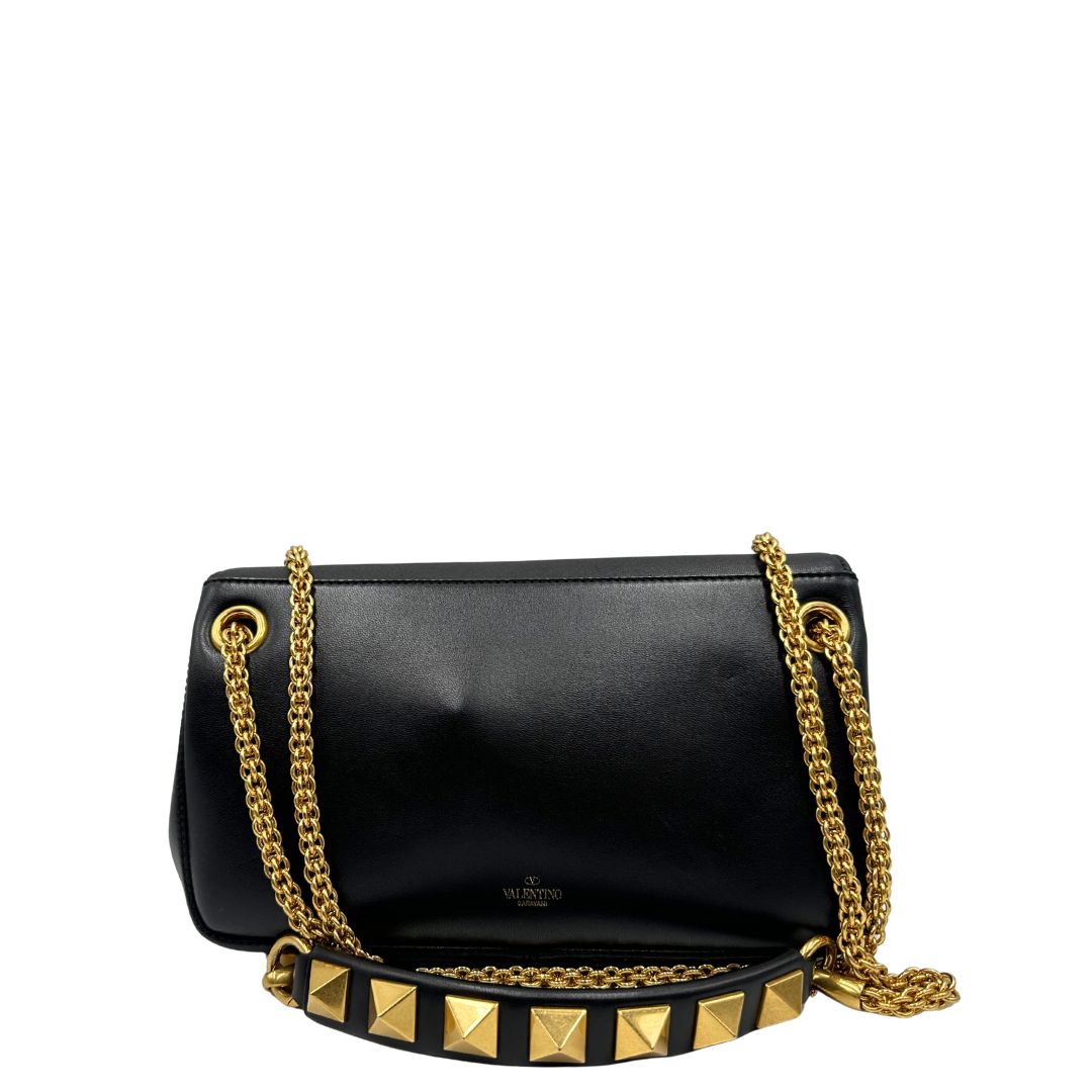 Retro di una Borsa Stud Sign Valentino Garavani in pelle nera con parti metalliche dorate e tracolla in catena scorrevole con borchie piramidali dorate sullo spallaccio. Completa di dustbag e cartellino. Originale, usata, di lusso, in ottime condizioni