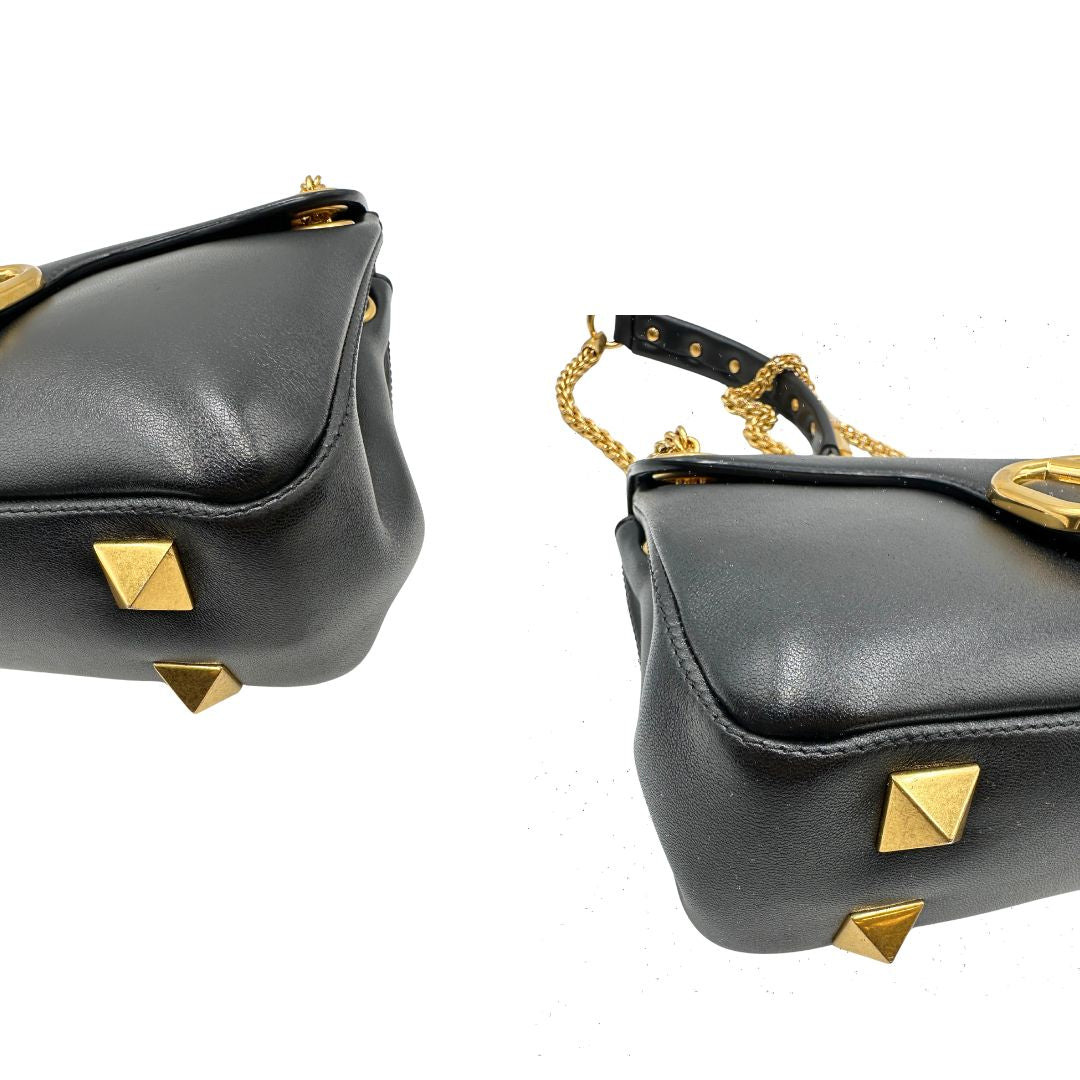 Angoli di una Borsa Stud Sign Valentino Garavani in pelle nera con parti metalliche dorate e tracolla in catena scorrevole con borchie piramidali dorate sullo spallaccio. Completa di dustbag e cartellino. Originale, usata, di lusso, in ottime condizioni