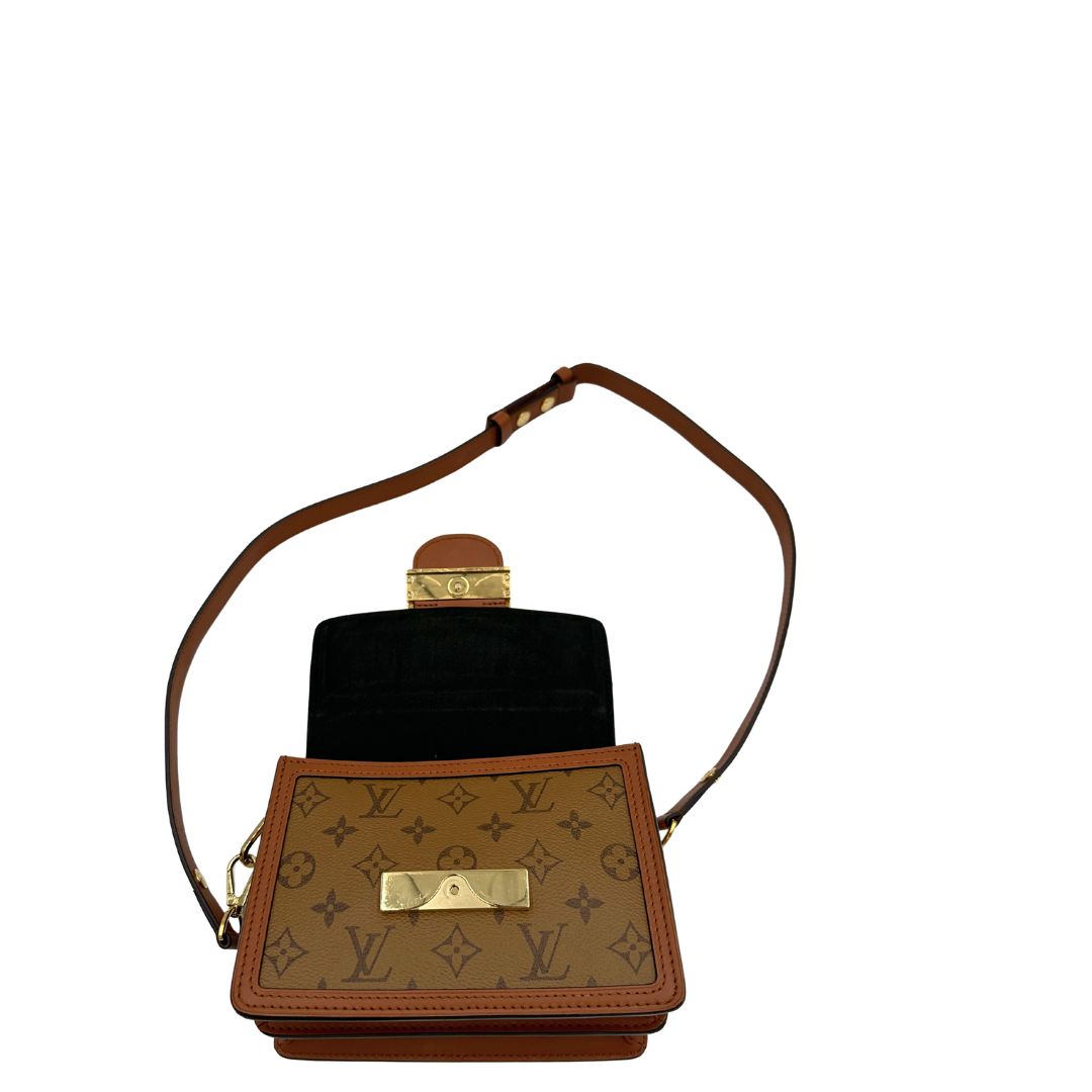 Interno di una Borsa Dauphine Mini Louis Vuitton in tela monogram, e monogram reverse bicolore con finiture in pelle cognac e parti metalliche dorate, munita di una tracolla in pelle allungabile e un manico in catena, amovibili. Originale, usata, di lusso, in ottime condizioni