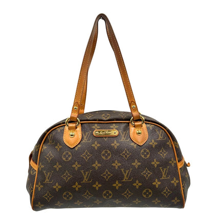 Front di una Borsa Montorgueil Louis Vuitton in canvas marrone monogram con finiture in vacchetta naturale e parti metalliche dorate; da indossare a spalla. Originale, usata, di lusso, in ottime condizioni.