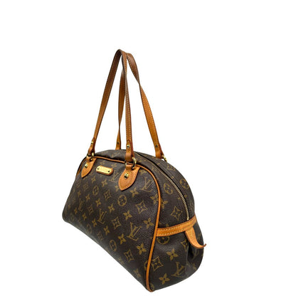 Angolo sinistro di una Borsa Montorgueil Louis Vuitton in canvas marrone monogram con finiture in vacchetta naturale e parti metalliche dorate; da indossare a spalla. Originale, usata, di lusso, in ottime condizioni.