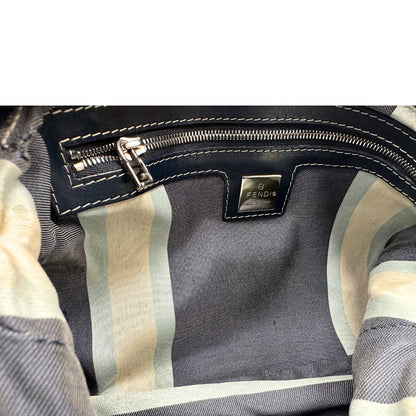 Interno di una borsa Fendi realizzata in tessuto blu navy con cuciture bianche a contrasto, manico leggermente regolabile e con parti metalliche argentate. Iconico logo effetto marble sulla chiusura della patta. Indossabile a spalla.