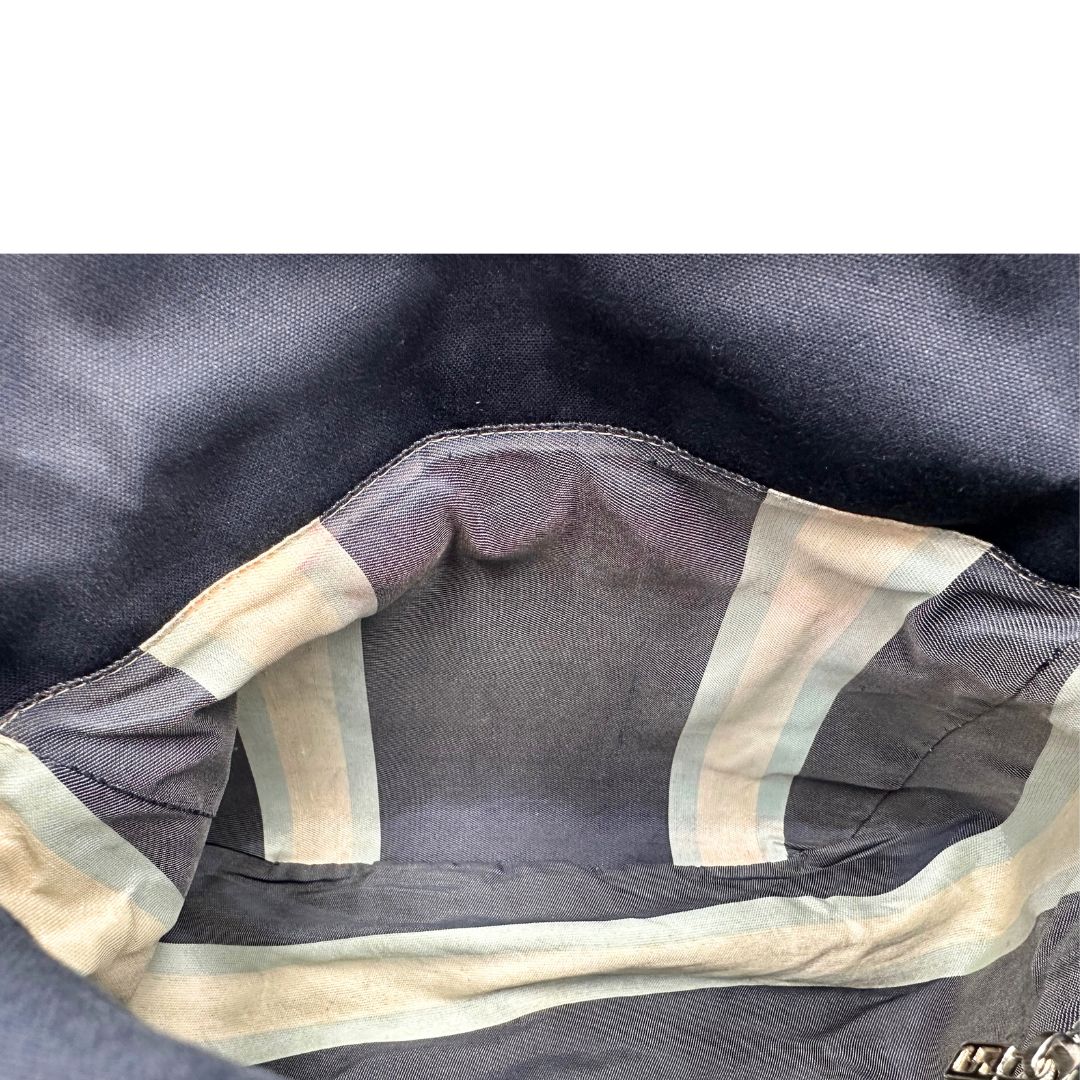 Interno di una borsa Fendi realizzata in tessuto blu navy con cuciture bianche a contrasto, manico leggermente regolabile e con parti metalliche argentate. Iconico logo effetto marble sulla chiusura della patta. Indossabile a spalla.