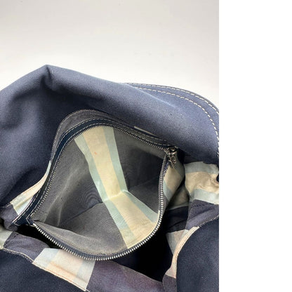 Interno di una borsa Fendi realizzata in tessuto blu navy con cuciture bianche a contrasto, manico leggermente regolabile e con parti metalliche argentate. Iconico logo effetto marble sulla chiusura della patta. Indossabile a spalla.