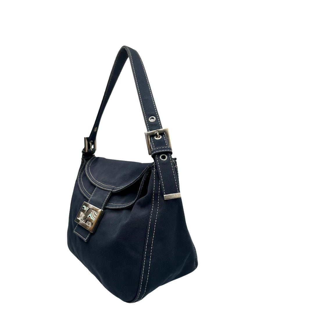 Laterale destro di una borsa Fendi realizzata in tessuto blu navy con cuciture bianche a contrasto, manico leggermente regolabile e con parti metalliche argentate. Iconico logo effetto marble sulla chiusura della patta. Indossabile a spalla.