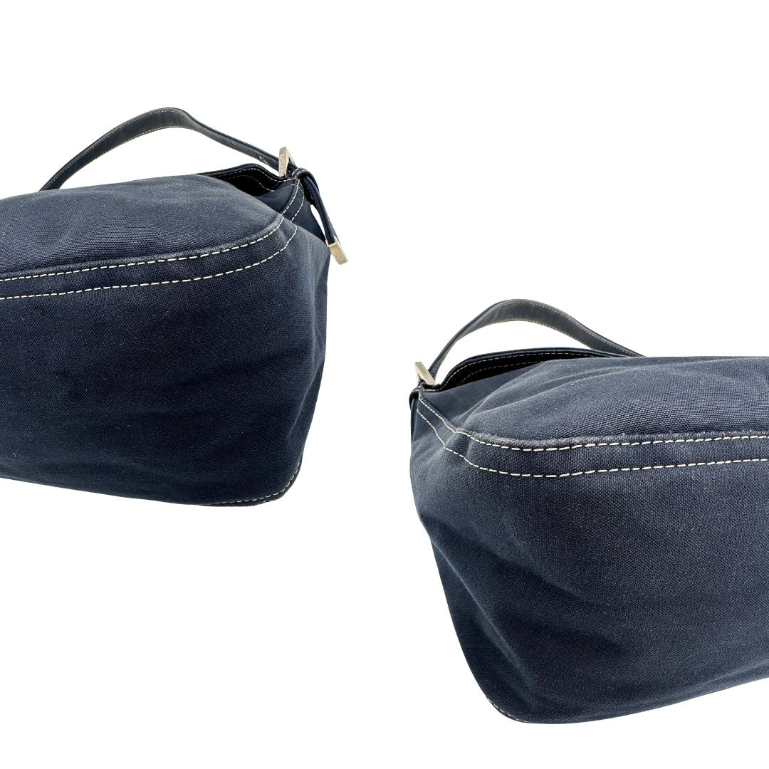 Angoli di una borsa Fendi realizzata in tessuto blu navy con cuciture bianche a contrasto, manico leggermente regolabile e con parti metalliche argentate. Iconico logo effetto marble sulla chiusura della patta. Indossabile a spalla.