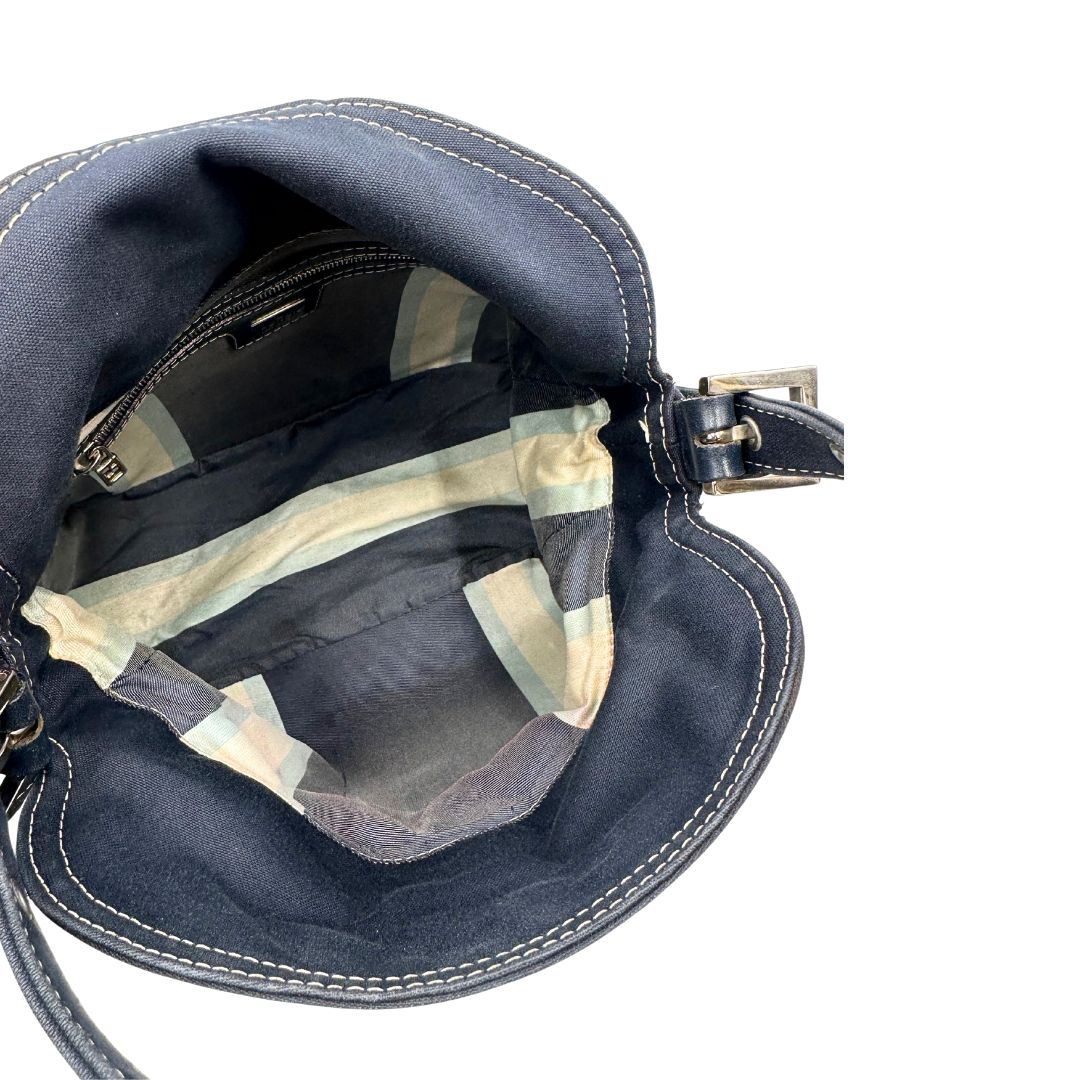 Interno di una borsa Fendi realizzata in tessuto blu navy con cuciture bianche a contrasto, manico leggermente regolabile e con parti metalliche argentate. Iconico logo effetto marble sulla chiusura della patta. Indossabile a spalla.