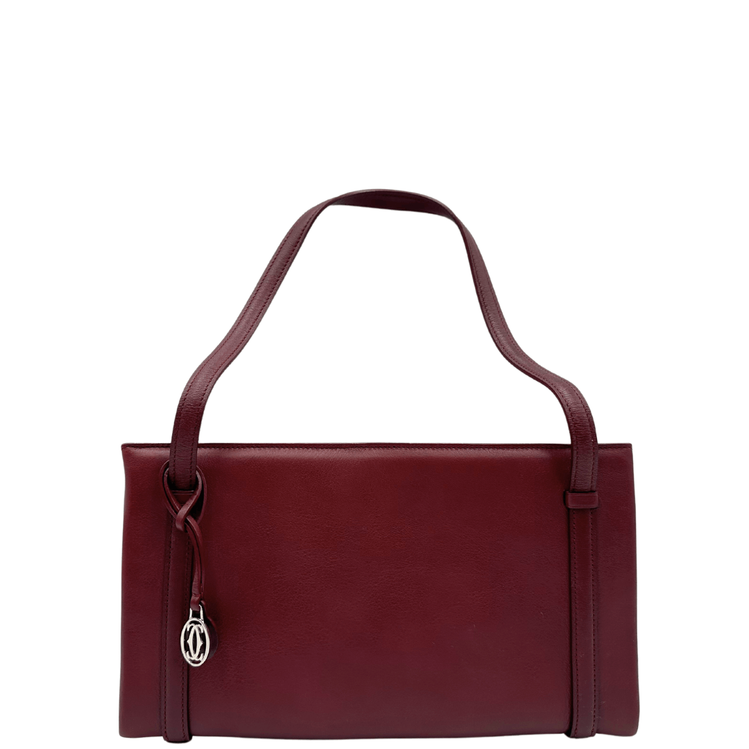 Elegante borsa a spalla Cartier in pelle bordeaux con dettagli raffinati e charm logo. Perfetta per un look sofisticato e senza tempo.