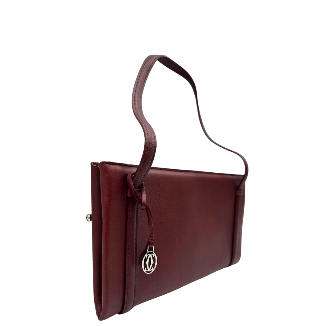 Elegante borsa a spalla Cartier in pelle bordeaux con dettagli raffinati e charm logo. Perfetta per un look sofisticato e senza tempo.