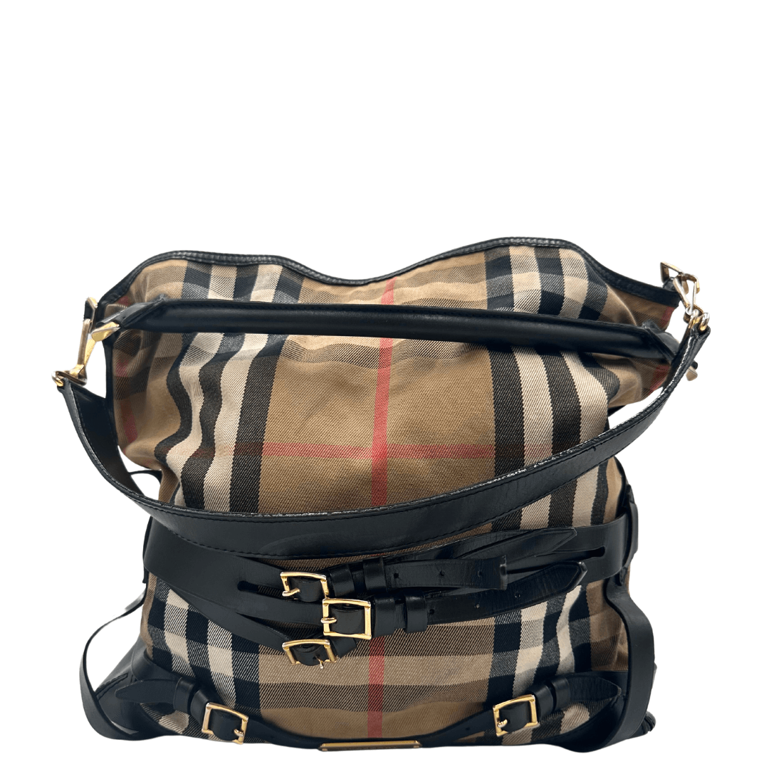 Shopper Burberry con l'iconico motivo check, dotata di tracolla amovibile in pelle e dettagli in metallo dorato. Un accessorio elegante e versatile, perfetto per aggiungere un tocco di classe britannica a qualsiasi outfit.