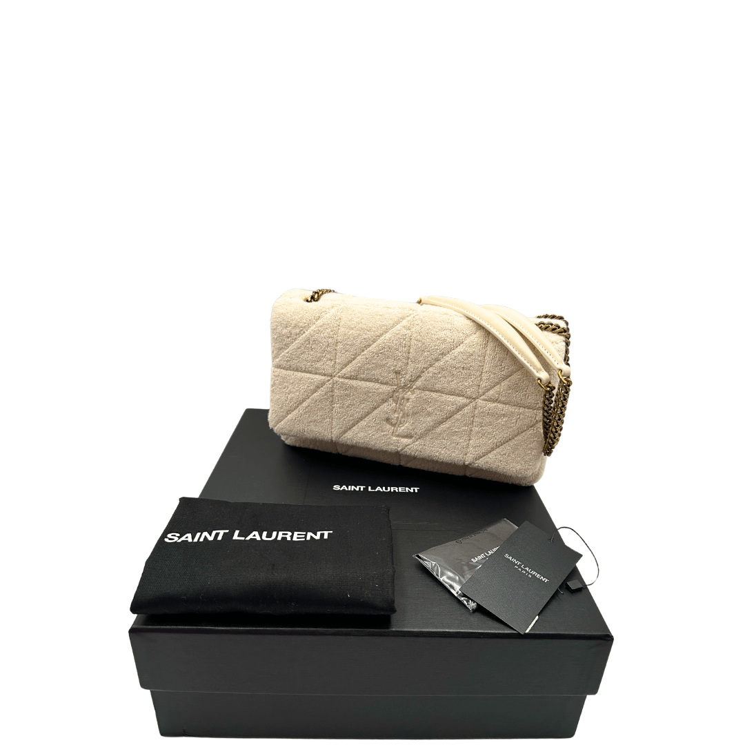 Scopri la borsa YSL Jamie in tessuto bouclé crema, con logo YSL ton-sur-ton e tracolla a catena dorata. Eleganza e versatilità per ogni occasione.