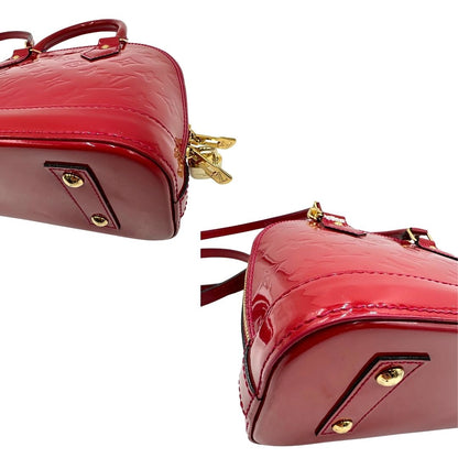 angoli Borsa Louis Vuitton Alma BB in pelle vernis rossa con trama monogram empreinte e parti metalliche dorate. Munita di doppi manici stondati e tracolla amovibile, dotata di clochette porta chiavi. Completa di scatola, lucchetto e chiavi, di lusso, originale, ottime condizioni. 