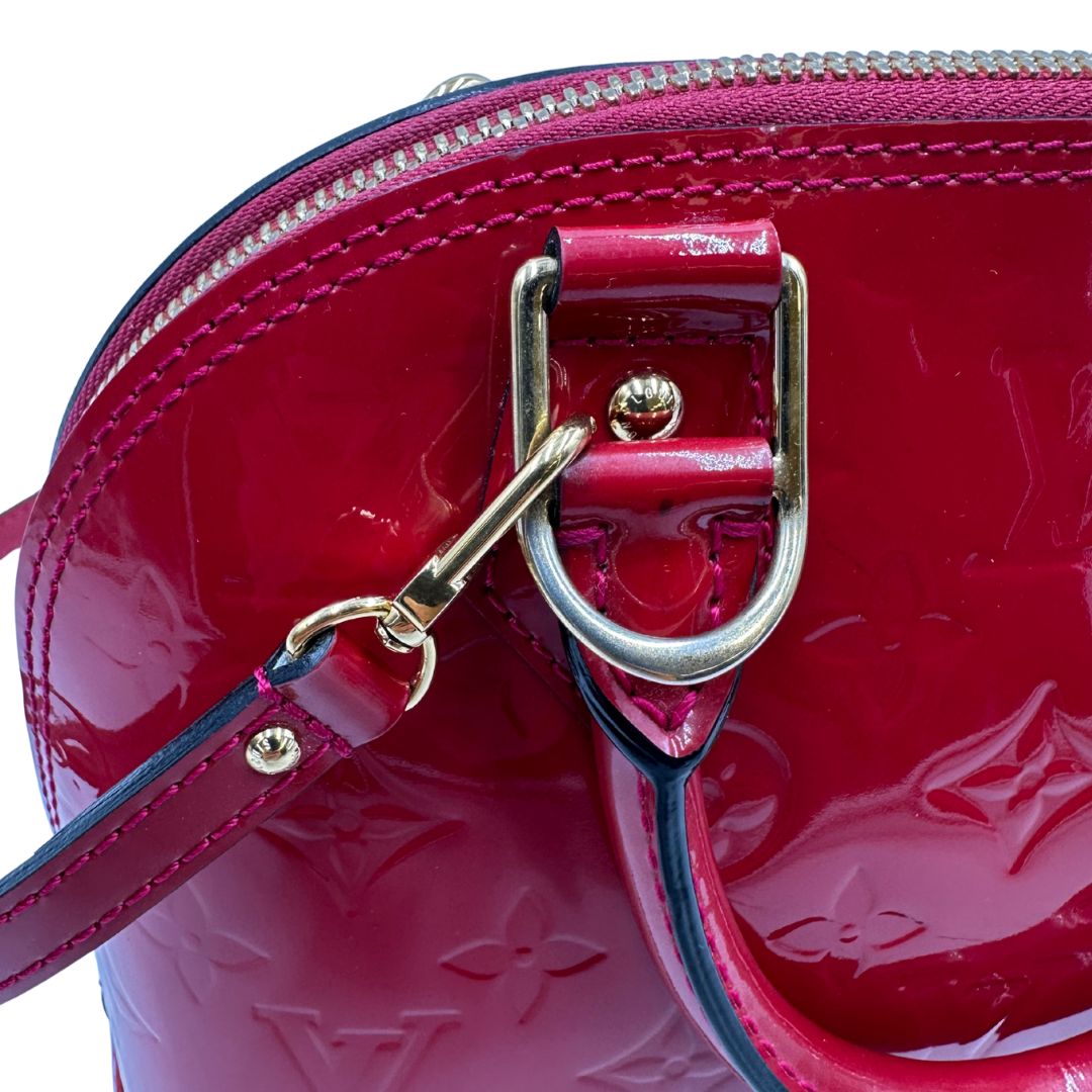 metalleria Borsa Louis Vuitton Alma BB in pelle vernis rossa con trama monogram empreinte e parti metalliche dorate. Munita di doppi manici stondati e tracolla amovibile, dotata di clochette porta chiavi. Completa di scatola, lucchetto e chiavi, di lusso, originale, ottime condizioni. 