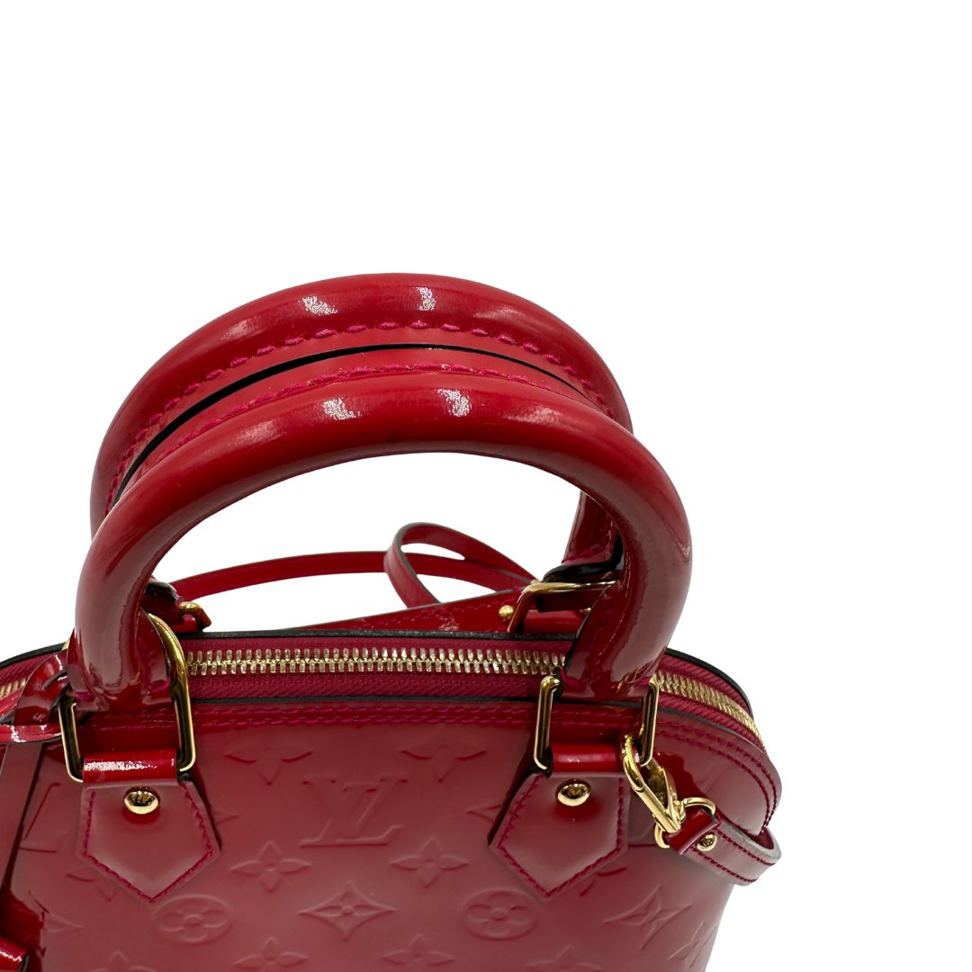 manici Borsa Louis Vuitton Alma BB in pelle vernis rossa con trama monogram empreinte e parti metalliche dorate. Munita di doppi manici stondati e tracolla amovibile, dotata di clochette porta chiavi. Completa di scatola, lucchetto e chiavi, di lusso, originale, ottime condizioni. 