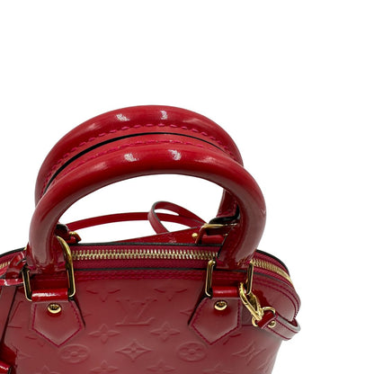 manici Borsa Louis Vuitton Alma BB in pelle vernis rossa con trama monogram empreinte e parti metalliche dorate. Munita di doppi manici stondati e tracolla amovibile, dotata di clochette porta chiavi. Completa di scatola, lucchetto e chiavi, di lusso, originale, ottime condizioni. 